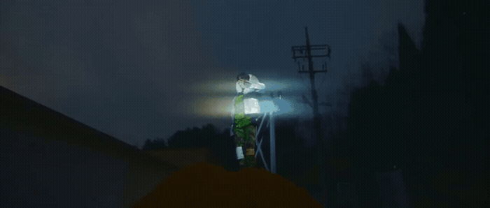 a person standing on top of a roof under a street light
