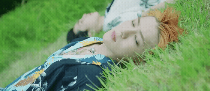 a woman laying in the grass with her eyes closed