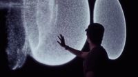 a person standing in front of a large screen