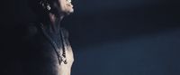 a man with no shirt standing in a dark room