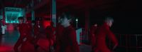 a group of people walking down a hallway at night