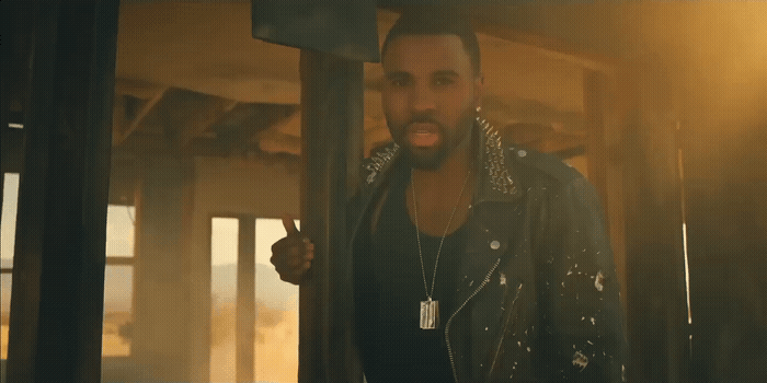 a man in a leather jacket standing in a room