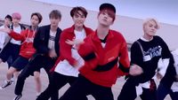 a group of young men dancing around each other