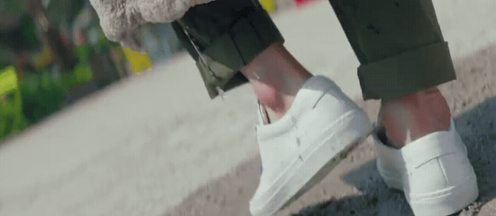 a person wearing white shoes and a furry coat