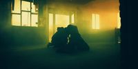 a couple of people kissing in a dark room