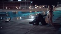 a man and a woman sitting next to a swimming pool