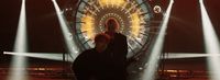 a couple of people standing in front of a ferris wheel