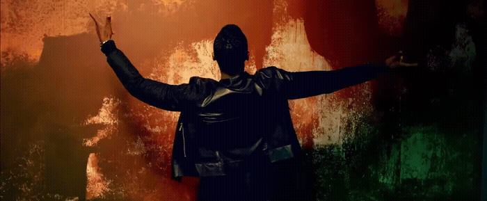 a man standing in front of a wall with his arms outstretched