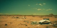 an abandoned building in the middle of a desert