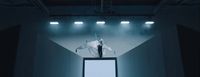 a man standing on top of a tv screen in a dark room