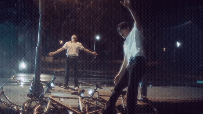a couple of men riding bikes down a street