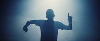 a silhouette of a man holding a knife in his right hand