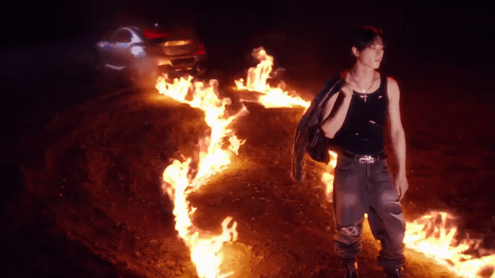 a woman standing in front of a bunch of fire