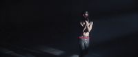a shirtless man standing in a dark room