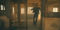 a man in a suit is walking through a room
