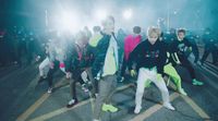 a group of young men dancing in a parking lot