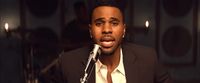 a man in a suit is singing into a microphone
