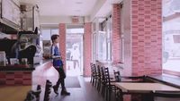 a woman standing at a counter in a restaurant