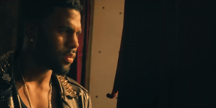 a man in a leather jacket looking out a window
