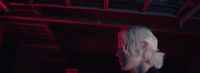 a woman with white hair standing in a dark room