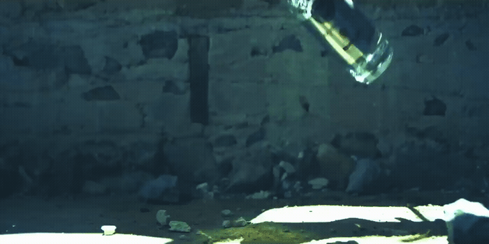 a skateboard flying through the air near a wall