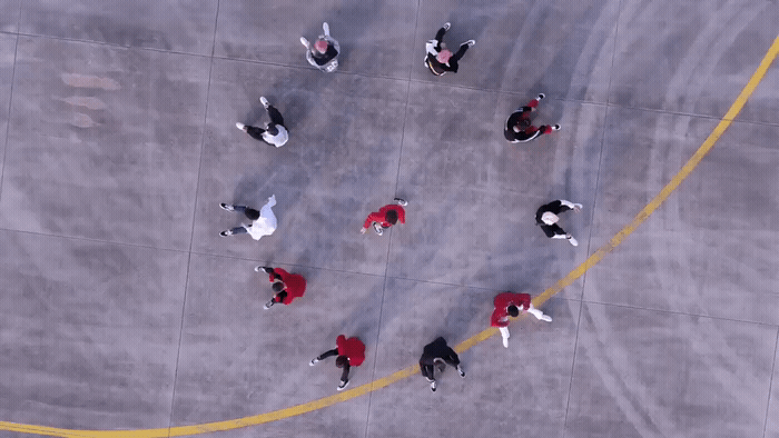 a group of people walking across a parking lot