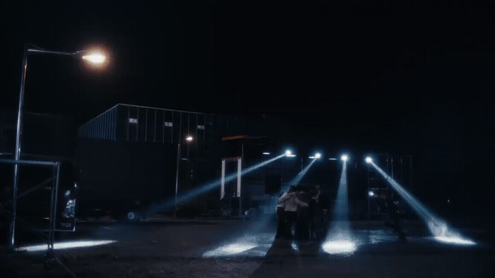 a group of people standing on a street at night