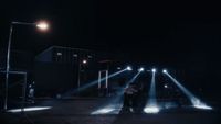 a group of people standing on a street at night