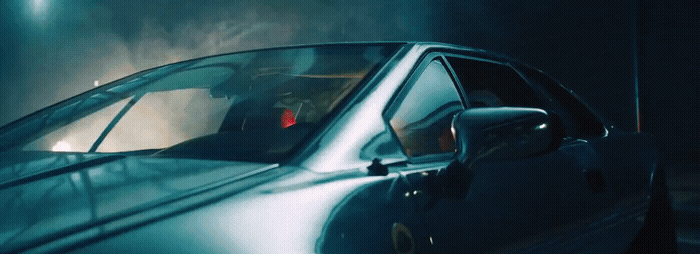 a blue car is parked in a dark room