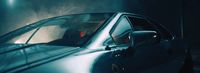 a blue car is parked in a dark room