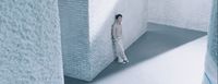 a man standing in a room with a brick wall