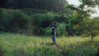 a man standing in a field of tall grass