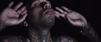 a man with tattoos and piercings on his chest