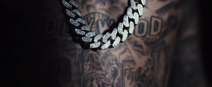 a man with a tattoo on his arm wearing a chain