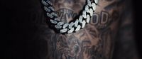 a man with a tattoo on his arm wearing a chain