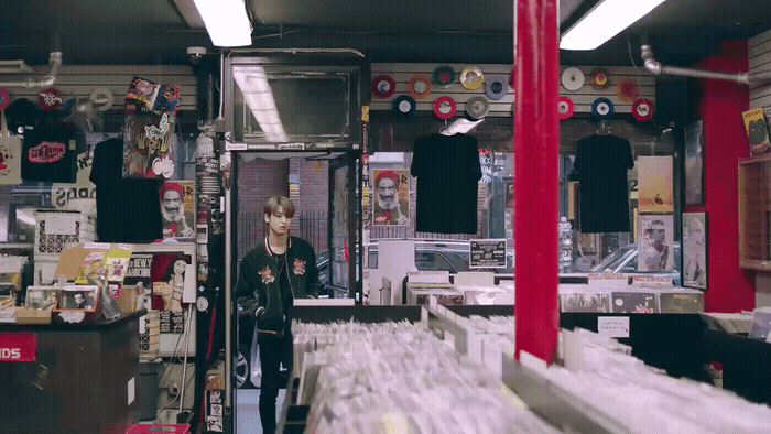 a man standing in a room filled with lots of records