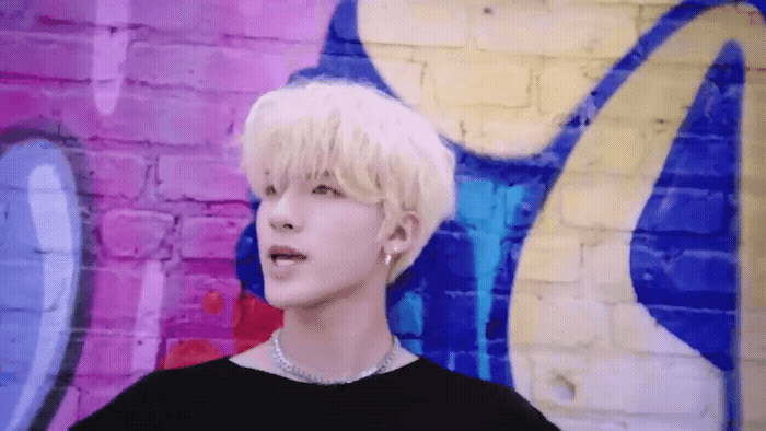 a person standing in front of a graffiti wall