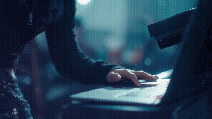 a person typing on a laptop in a dark room