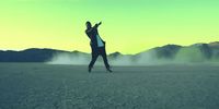 a man riding a skateboard across a desert