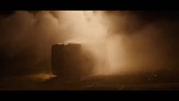 a large metal container sitting on top of a dirt field