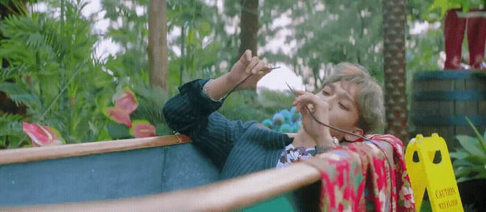 a woman sitting in a bathtub with a toothbrush in her mouth