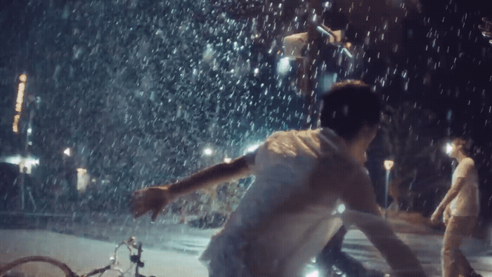 a man is running through the rain with his bicycle