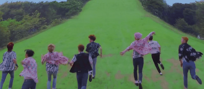 a group of people walking across a lush green field