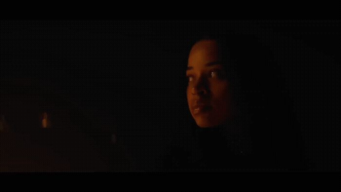 a woman in a dark room with a candle in her hand
