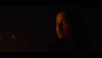 a woman in a dark room with a candle in her hand