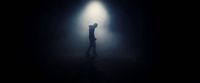a person standing in the dark with their arms up in the air