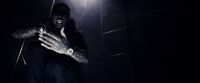 a man standing in a dark room with his hands in the air