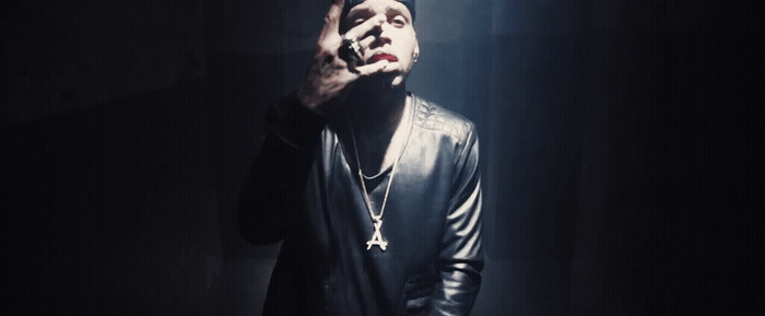 a man smoking a cigarette in a dark room