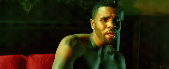 a shirtless man sitting on a red couch