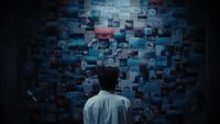 a man standing in front of a wall covered in pictures